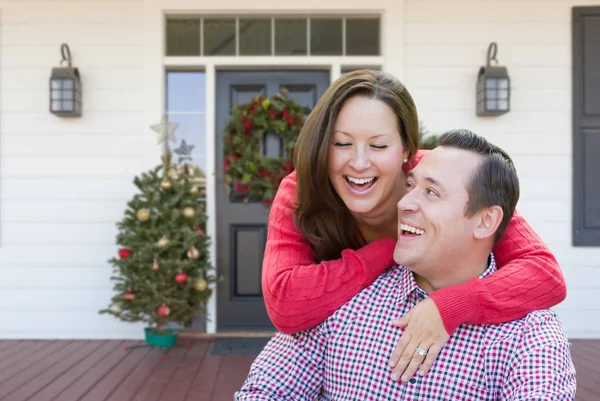 Felice giovane coppia ridendo sul portico anteriore della casa con decorazioni natalizie . — Foto Stock
