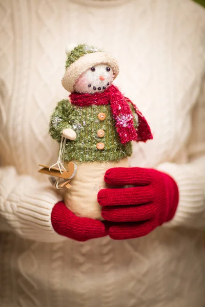 Mulher vestindo luvas vermelhas sazonais segurando boneco de neve de Natal — Fotografia de Stock