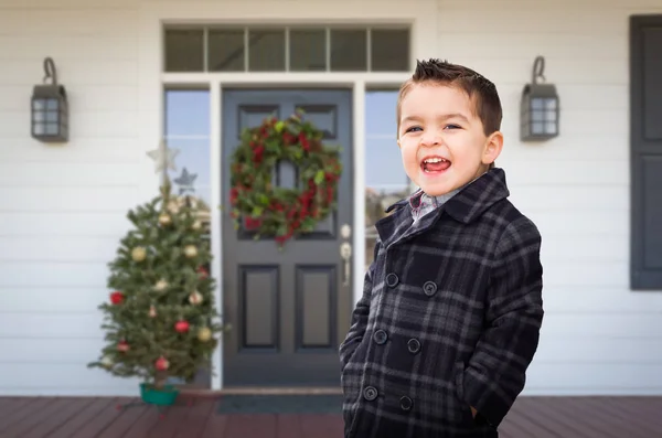 Menino de raça mista jovem na varanda da frente da casa com decorações de Natal . — Fotografia de Stock