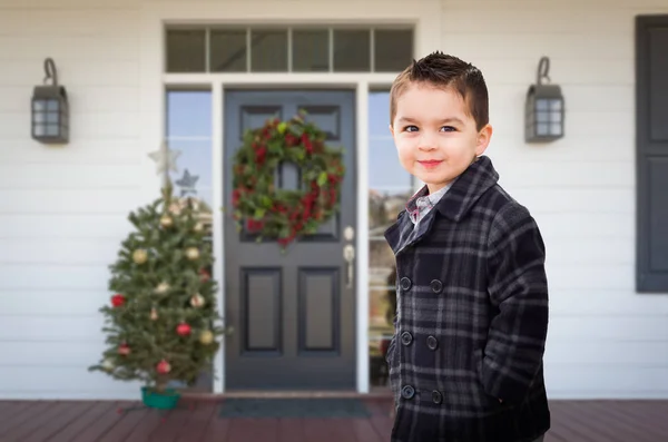 Ung blandras pojke på framsidan veranda av huset med juldekorationer. — Stockfoto
