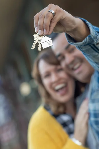 Couple mixte tenant de nouvelles clés de maison — Photo