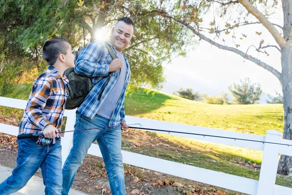 Raza mixta padre e hijo al aire libre caminando con los polacos de pesca —  Fotos de Stock