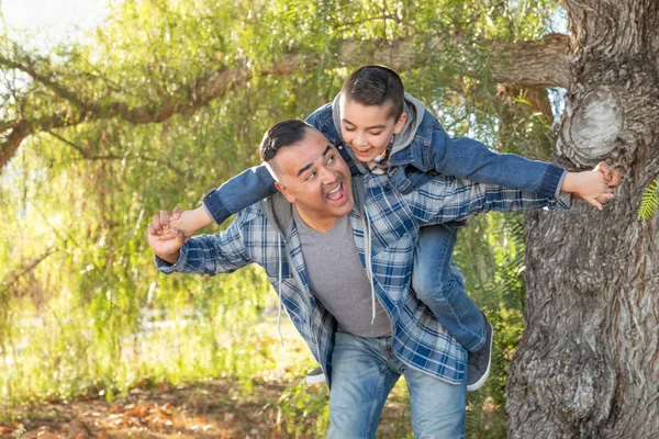 Mixta raza padre e hijo tener divertido piggy espalda al aire libre —  Fotos de Stock