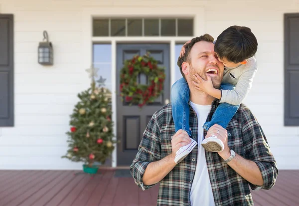 Misto raça chinês menino equitação piggyback no ombros de caucasiano pai no Natal decorado frente alpendre — Fotografia de Stock