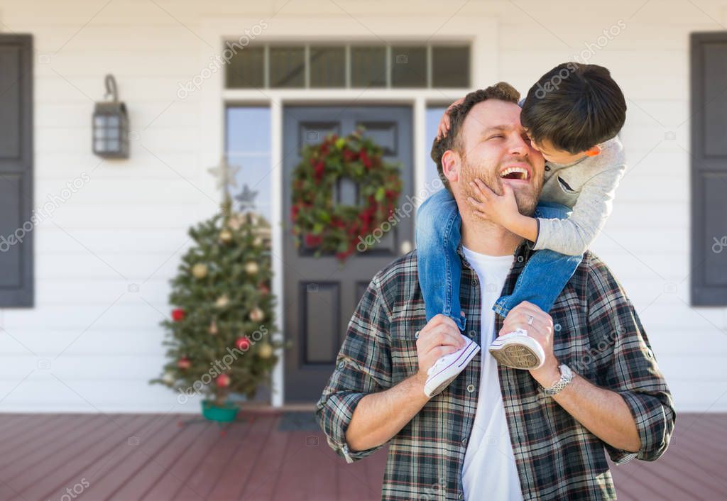 Mixed Race Chinese Boy Riding Piggyback on Shoulders of Caucasian Father On Christmas Decorated Front Porch