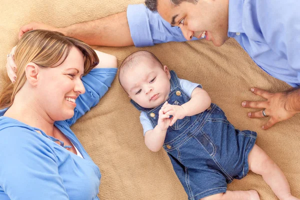 Junges Mischlingspaar legt sich mit Säugling auf eine Decke — Stockfoto