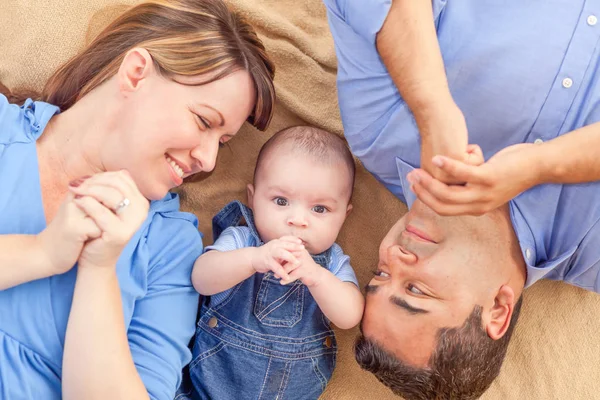 Young Mixed Race Couple Laying With Their Infant On A Blanket — Stock Photo, Image