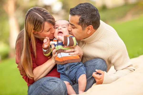 Familia de raza mixta feliz teniendo un picnic y jugando en el parque . —  Fotos de Stock