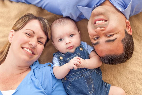 Young Mixed Race Couple Laying With Their Infant On A Blanket — Stock Photo, Image