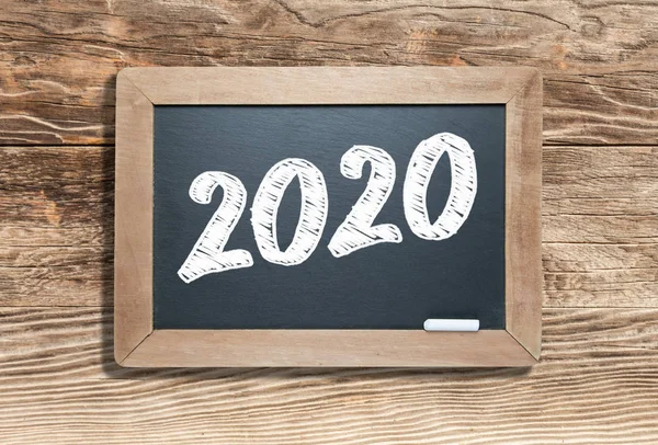 2020 scris pe Slate Chalk Board Against Aged Wood Background — Fotografie, imagine de stoc