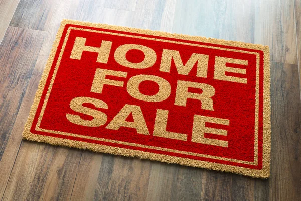 Home Te koop Welkom Mat Op Een Hout Vloer Achtergrond — Stockfoto