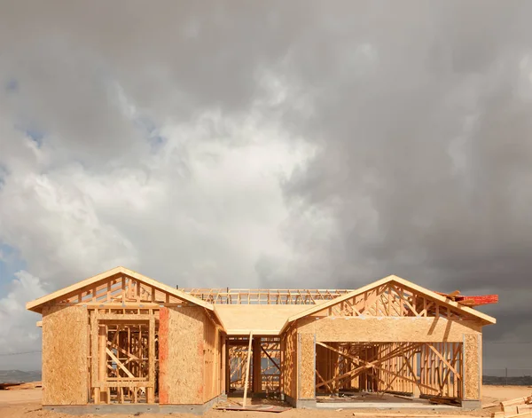 Holzhaus-Einrahmung auf Baustelle mit stürmischen Wolken im Hintergrund — Stockfoto