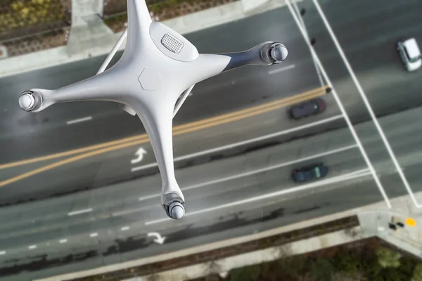 Système d'aéronef sans pilote Quadcopter Drone dans les airs sur la route avec des automobiles — Photo