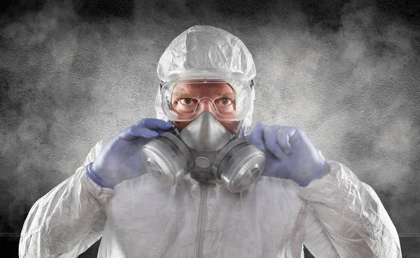 Hombre con traje de materiales peligrosos, gafas y máscara de gas es ahumado habitación oscura —  Fotos de Stock