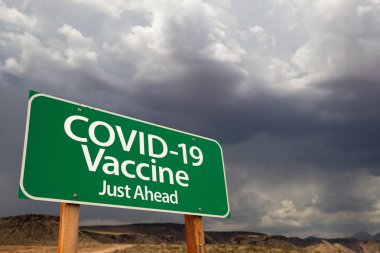 COVID-19 Coronavirus Aşısı Uğursuz Bulutlu Gökyüzüne Yeşil Yol İşareti.