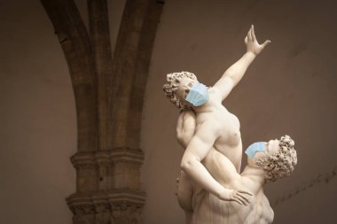 The Kidnapping of the Sabine Women Statue by Giambologna, in the Loggia dei Lanzi in Florence Italy With Face Masks - Coronavirus Scare. clipart