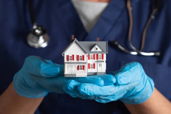 Female Doctor Nurse Wearing Surgical Gloves Holding Model Home — Stock Photo, Image