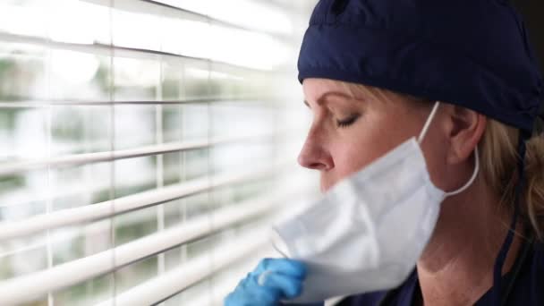 Stressad Läkare Eller Sjuksköterska Paus Vid Fönstret Bort Medicinska Ansiktsmask — Stockvideo