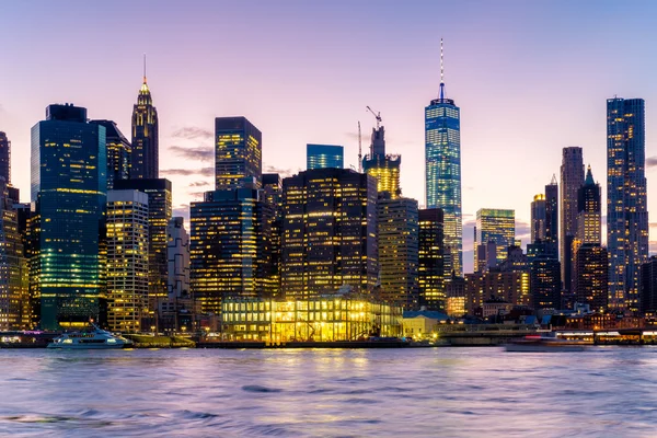 Puesta de sol en la ciudad de Nueva York con vistas al horizonte iluminado — Foto de Stock