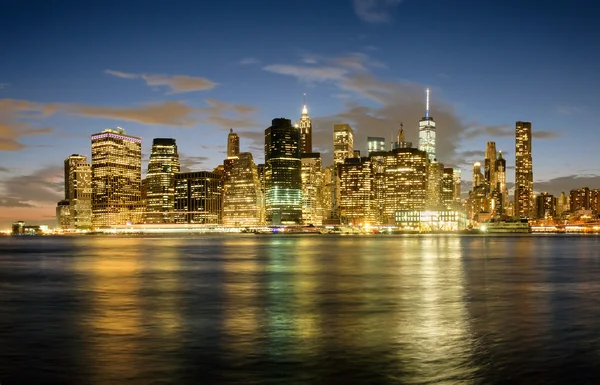 El horizonte del centro de Manhattan al atardecer con reflejos sobre el — Foto de Stock