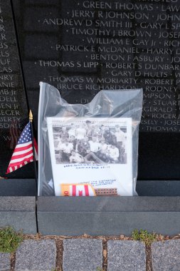Photograph and american flag left as tributes at the Vietnam Vet clipart