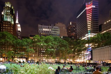 Midtown Manhattan gökdelenler tarafından çevrili gece Bryant Park'ta