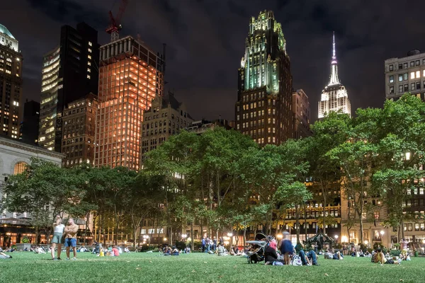 Midtown Manhattan gökdelenler tarafından çevrili gece Bryant Park'ta