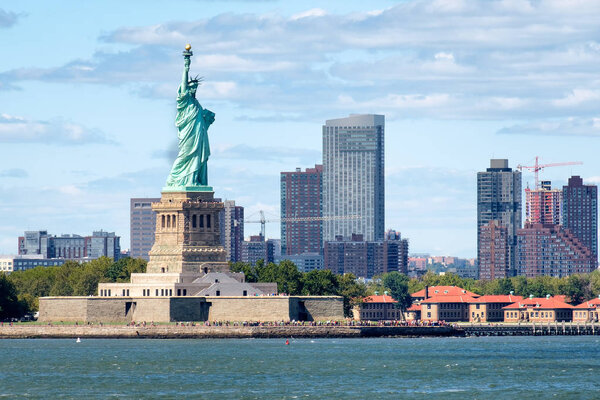 The Statue of Liberty in New York City with skyscrapers on the background