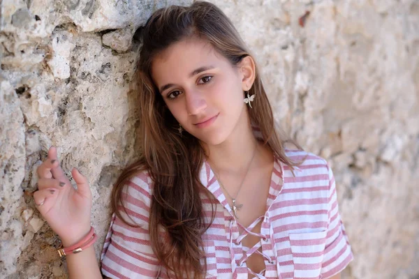 Retrato de una hermosa adolescente hispana apoyada en una piedra wa — Foto de Stock