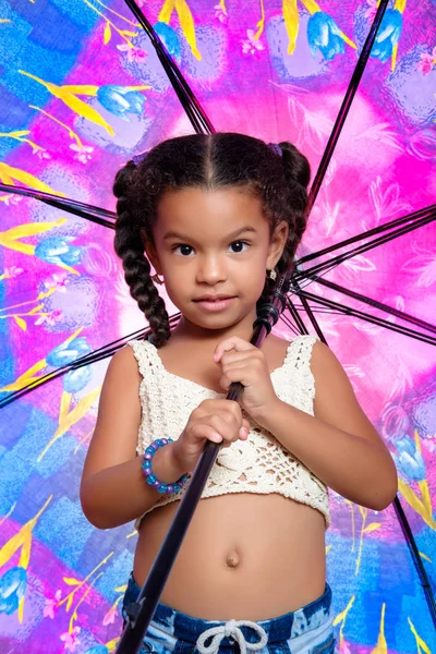 Linda afroamericana niña pequeña sosteniendo un paraguas colorido — Foto de Stock
