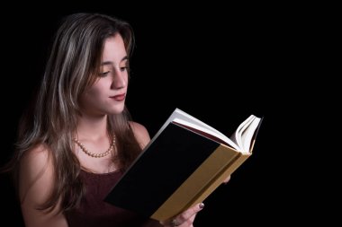 Güzel ttenage kız siyah izole bir kitap okuma