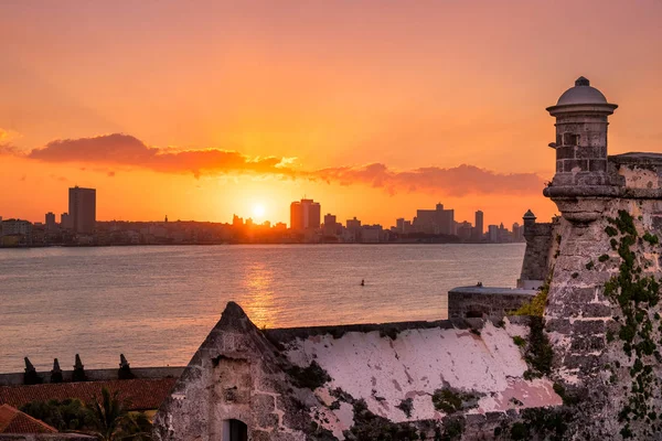 Puesta de sol en La Habana con la puesta de sol sobre los edificios y el Morro en primer plano —  Fotos de Stock