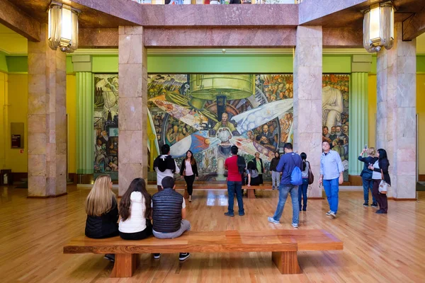 Bezoekers bewonderen de muurschilderingen van Diego Rivera op het Palacio de Bellas Artes in Mexico-stad — Stockfoto