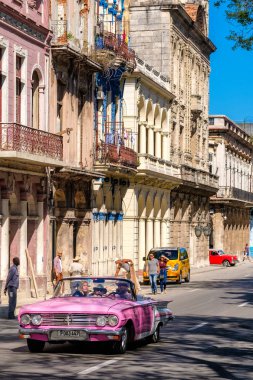 Turistler eski Havana çevresinde sürüş klasik Cabrio araba