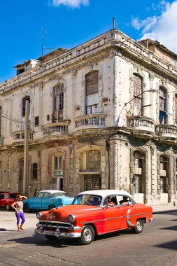 Çöken bir eski Havana'da bina yanındaki eski model Amerikan araba