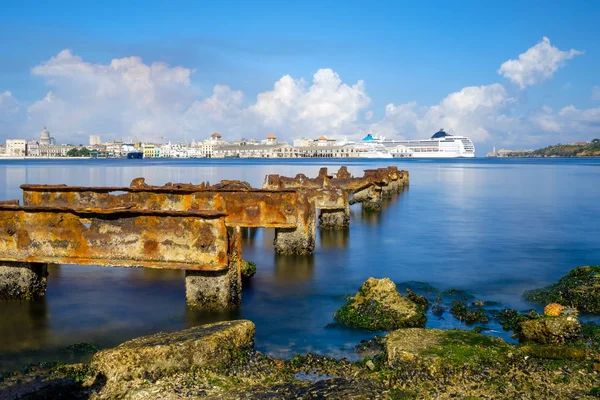 De baai van Havana en de skyline van oud Havana met een roestig ijzer pier op de voorgrond — Stockfoto