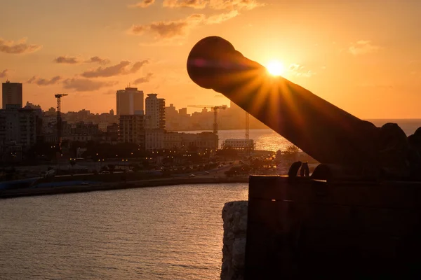 La Havane au coucher du soleil avec la silhouette d'un vieux canon au premier plan — Photo