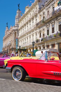 Vintage arabalar Eski Havana'da bir otel yanında turistler için bekliyor