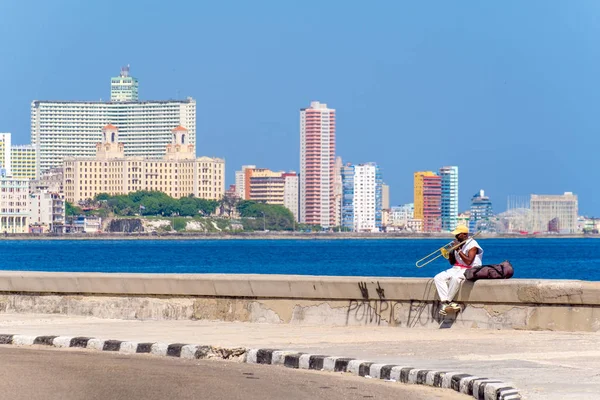 Pouliční muzikant hraje na trombón na zeď slavných malecon v Havaně — Stock fotografie