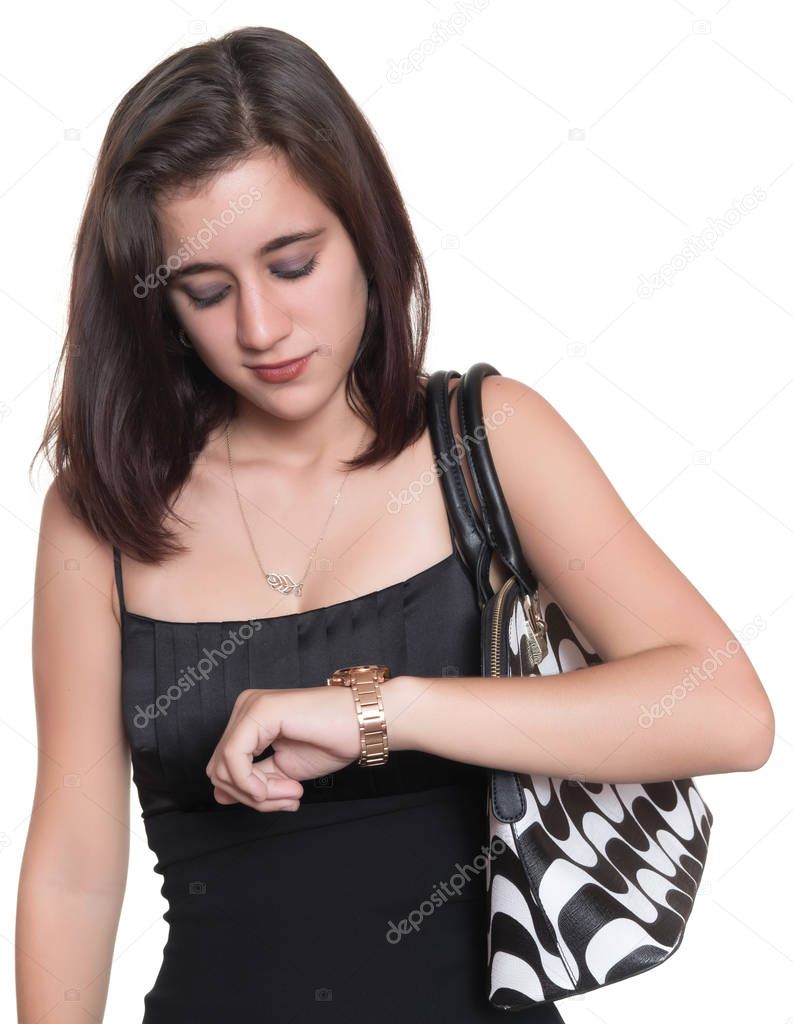 Beautiful teenage girl wearing an elegant black dress checking the time on her watch