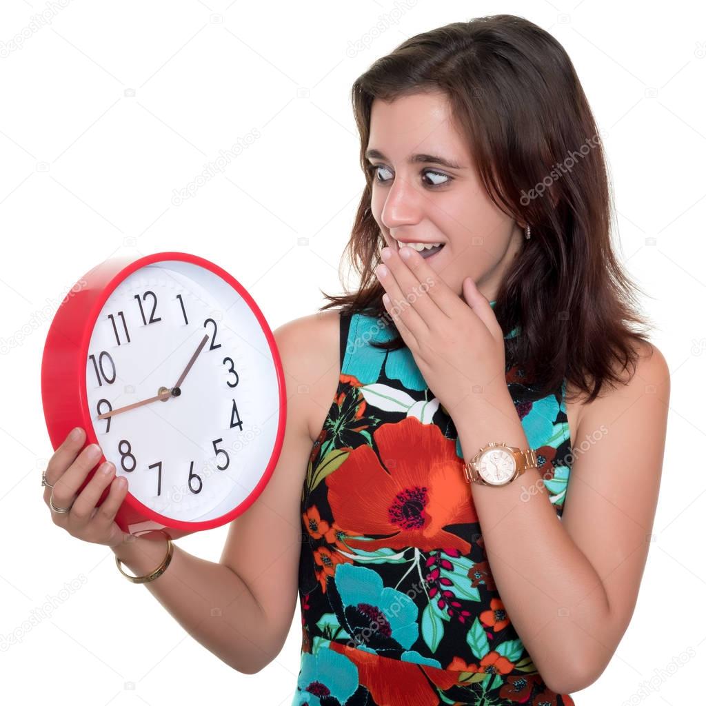 Teenage girl with a surprised expression checking the time on a big clock