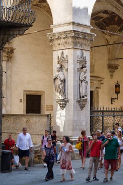 Siena ortaçağ şehir eski bir binanın yanındaki turist,