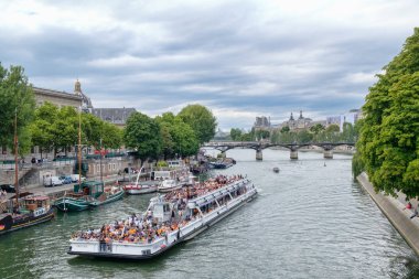 Paris'in merkezinde Seine Nehri boyunca turistler bir gezi tekne alır