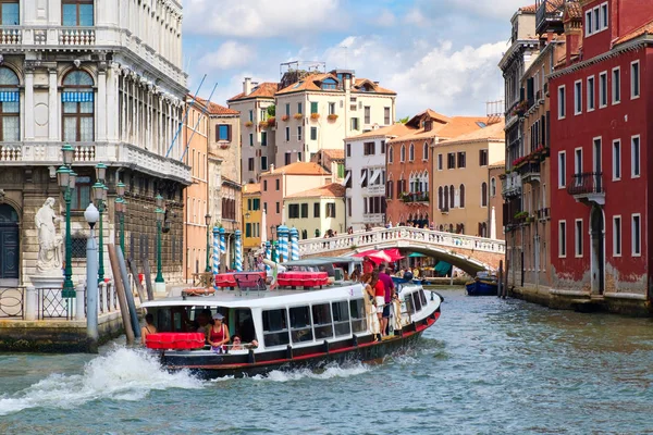 Вапоретто или водный автобус на канале в Венеции в окружении старых зданий — стоковое фото