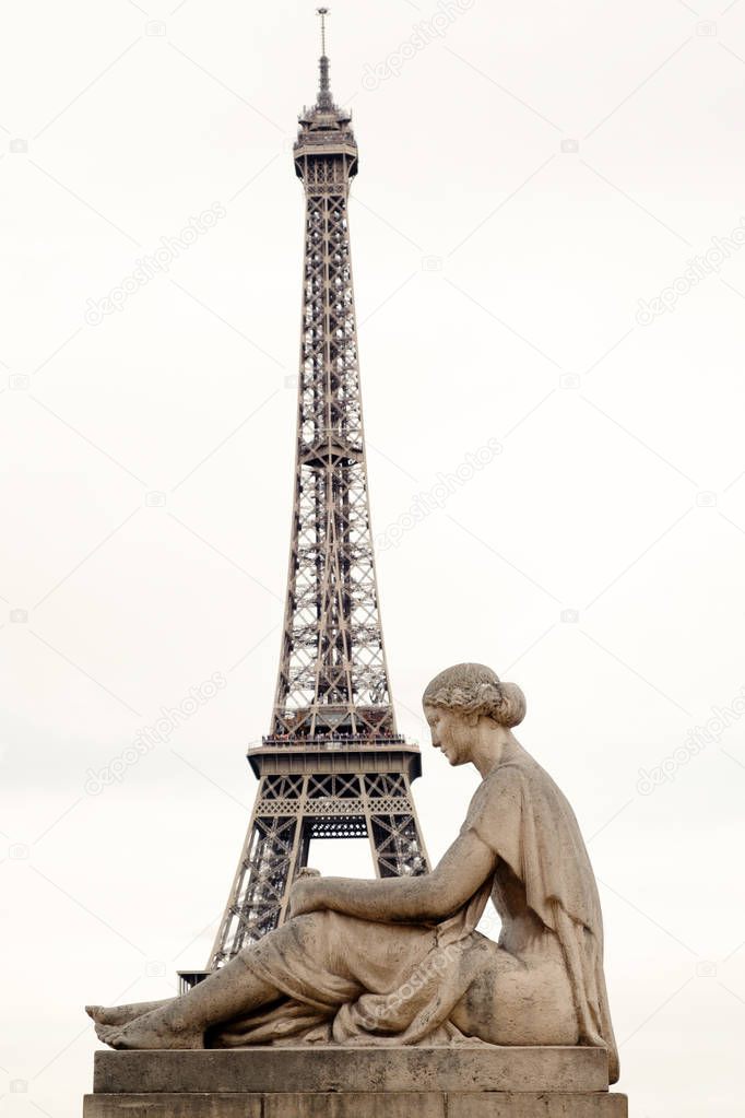 Old statue of a pensive woman at the Palace de Chaillot with the Eiffel Tower on the background