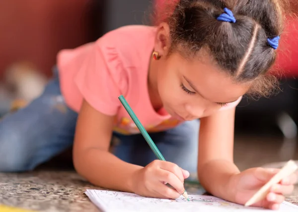 Linda niña multirracial dibujando en un libro para colorear — Foto de Stock