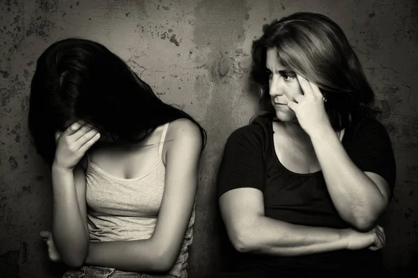 Teenage girl cries next to her angry and worried mother — Stock Photo, Image
