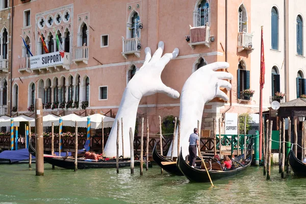 Riesige Hände stützen einen alten Palast neben dem großen Kanal in Venedig — Stockfoto