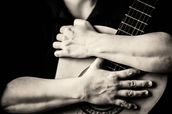 Mani che abbracciano una chitarra acustica — Foto Stock