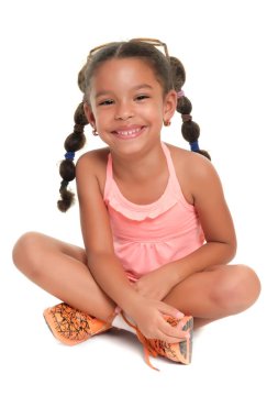 Katta oturan ve gülümseyen sevimli çok ırklı küçük kız